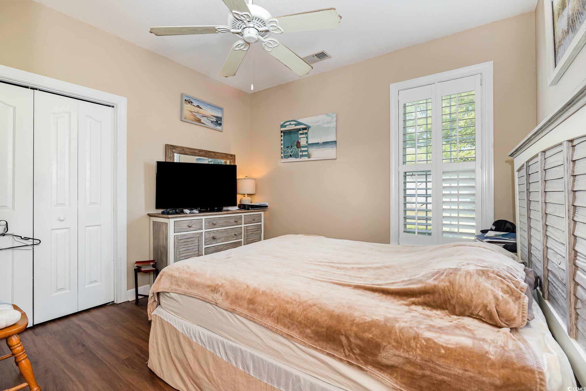 1004 Addington Court Murrells Inlet, SC 29576 - Photo 24 of 40 Bedroom featuring dark wood-type flooring, a closet, and a ceiling fan