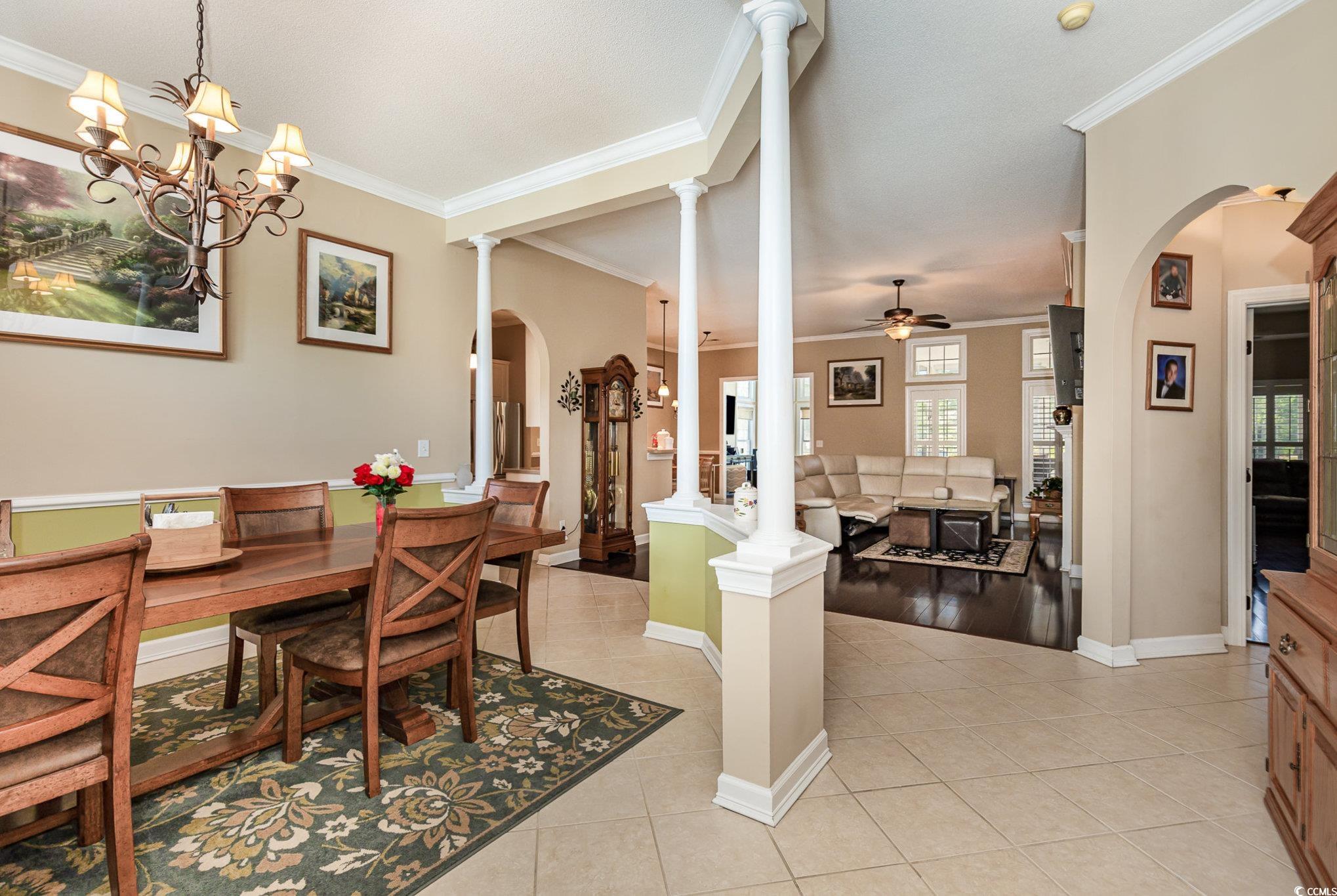 1004 Addington Court Murrells Inlet, SC 29576 - Photo 4 of 40 Dining space with arched walkways, crown molding, ceiling fan, light tile patterned floors, and decorative columns