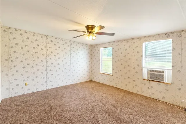 a view of a livingroom with a chandelier fan and a window