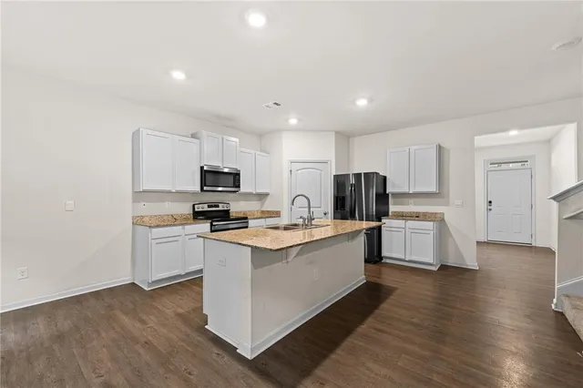 a kitchen with white cabinets and stainless steel appliances