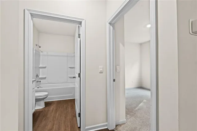 a bathroom view of a toilet and a mirror