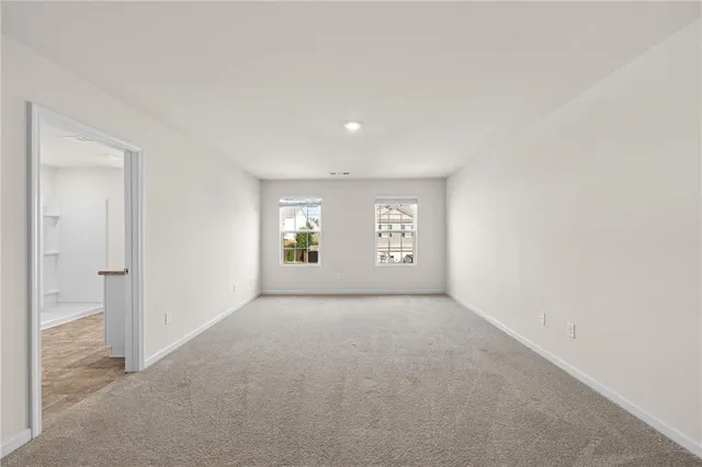 an empty room with windows and mirror