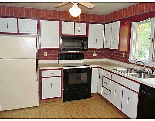 481 Ross Road Eighty Four, PA 15330 - Photo 4 of 16 Kitchen. The kitchen is accented with brick consistent with the rest of the home, wood cabinetry, refrigerator, electric stove, microwave, and dishwasher. There s also room for a table or breakfast nook