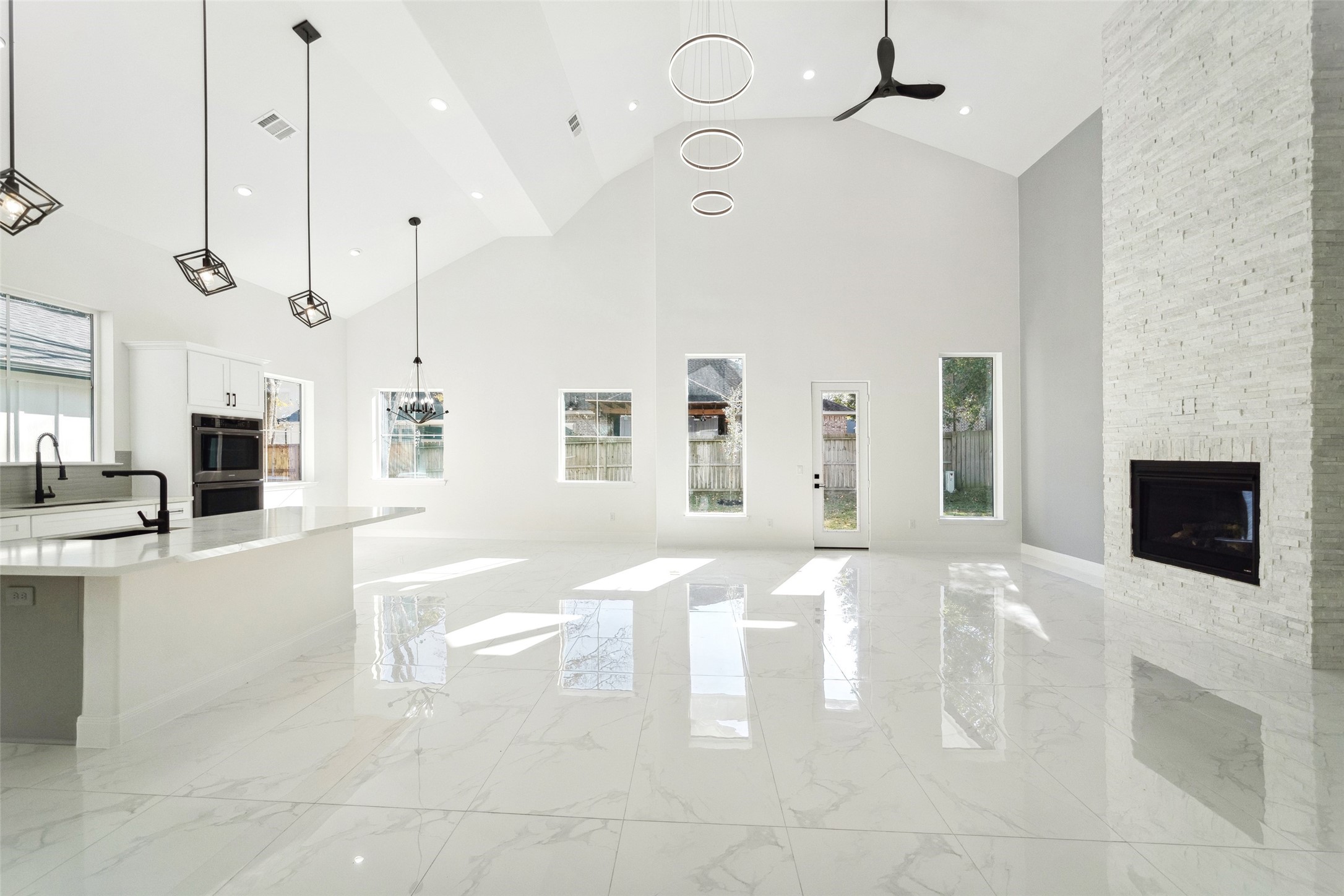 75 Wick Willow Road Montgomery, TX 77356 - Photo 15 of 46 "Stunning modern open-concept living space featuring soaring ceilings, sleek marble-style flooring, designer lighting, and beautiful windows filling the home with natural light."