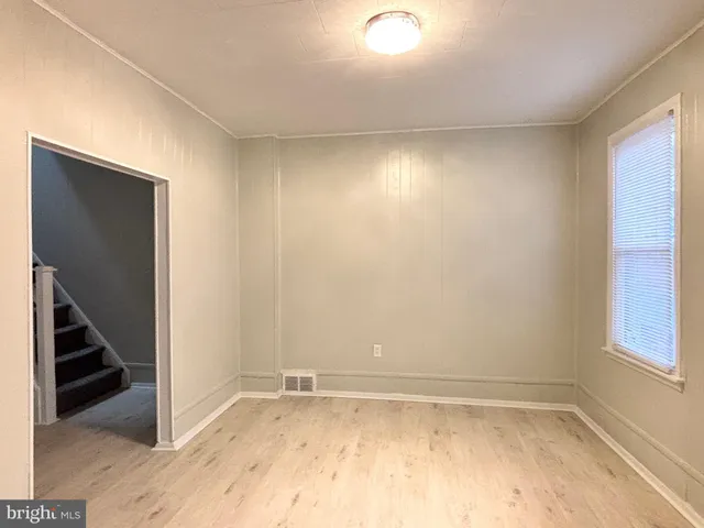 a view of an empty room with wooden floor and entryway