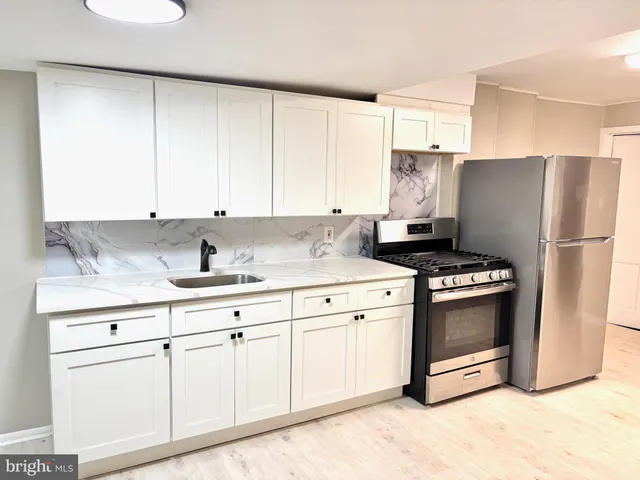 a kitchen with granite countertop white cabinets and white appliances