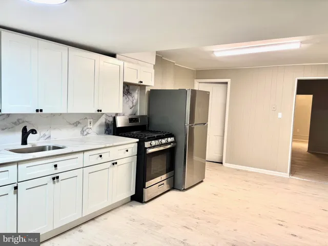 a kitchen with stainless steel appliances granite countertop a refrigerator and a stove