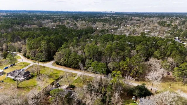 an aerial view of residential houses with outdoor space and trees