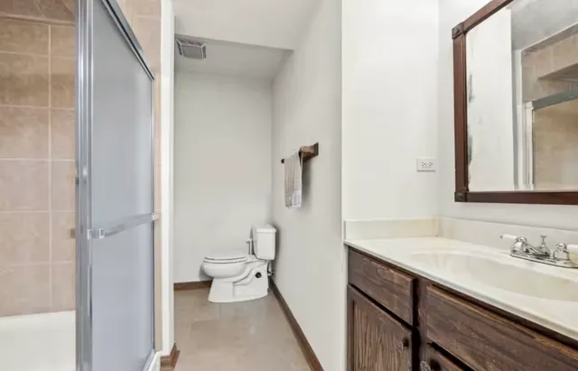 a bathroom with a sink a toilet and shower