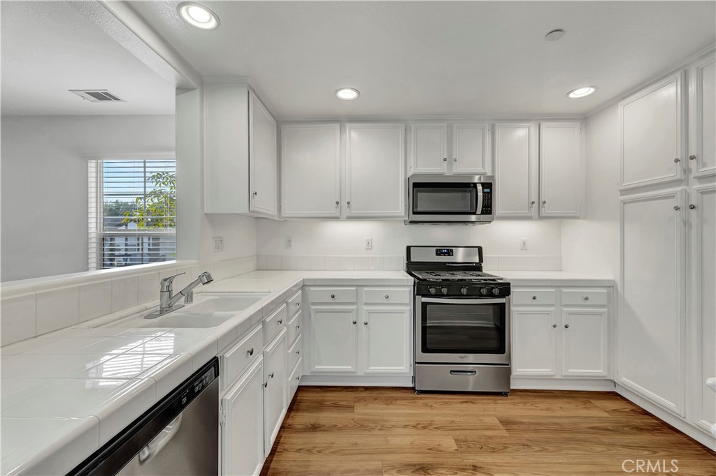 40 Three Vines Court Ladera Ranch, CA 92694 - Photo 13 of 28 a kitchen with stainless steel appliances granite countertop a stove top oven a sink and a microwave