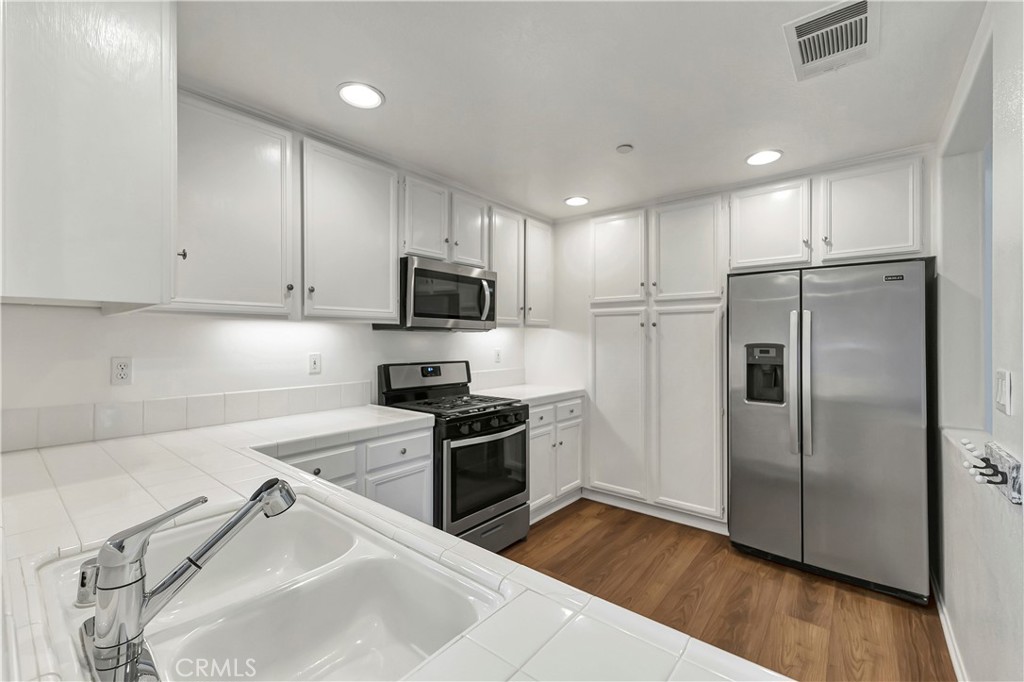 40 Three Vines Court Ladera Ranch, CA 92694 - Photo 14 of 28 a kitchen with wooden cabinets and stainless steel appliances