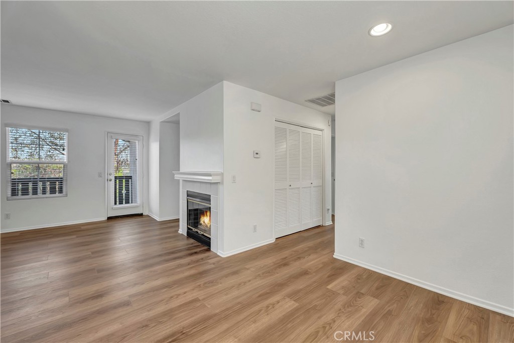 40 Three Vines Court Ladera Ranch, CA 92694 - Photo 9 of 28 an empty room with wooden floor fireplace and windows