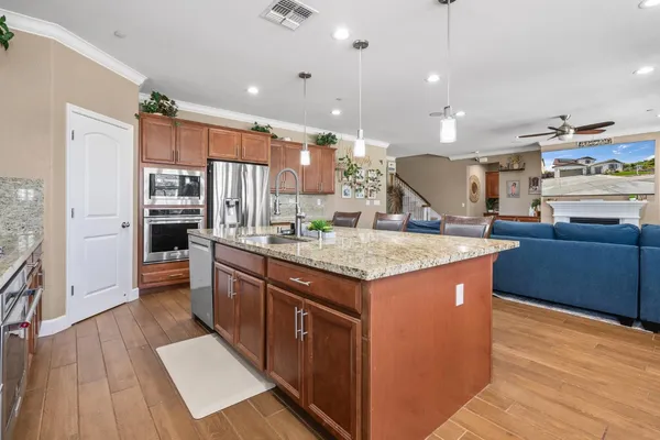 a kitchen with granite countertop a sink a counter space appliances and a large window