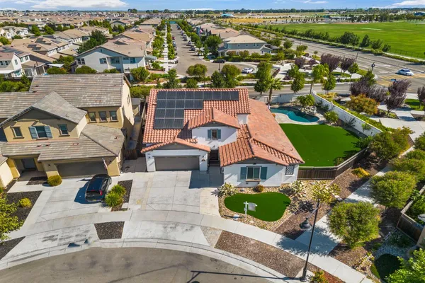 an aerial view of a house with a garden and lake view