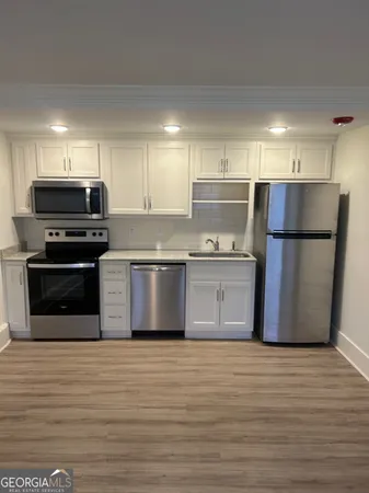 a kitchen with stainless steel appliances granite countertop a refrigerator sink and microwave