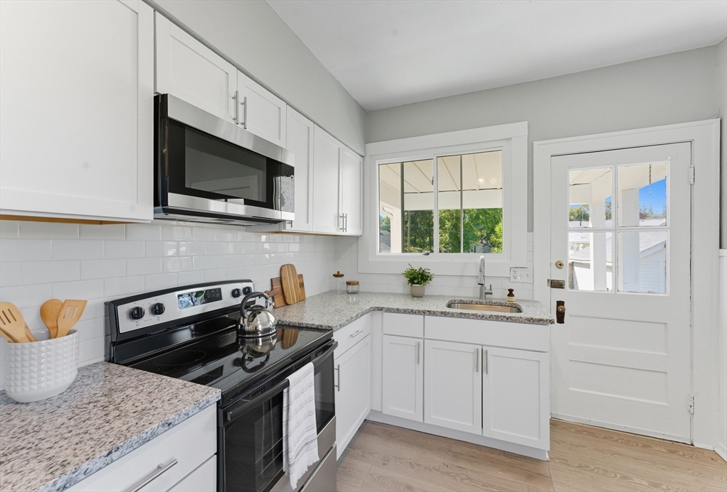 33 Taber Street Springfield, MA 01118 - Photo 11 of 39 a kitchen with stainless steel appliances granite countertop white cabinets a sink and a stove