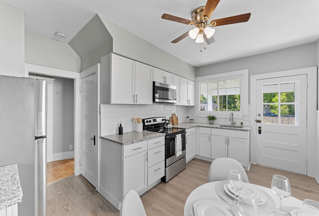 33 Taber Street Springfield, MA 01118 - Photo 13 of 39 a kitchen with stainless steel appliances granite countertop a stove a sink dishwasher a refrigerator white cabinets and wooden floor