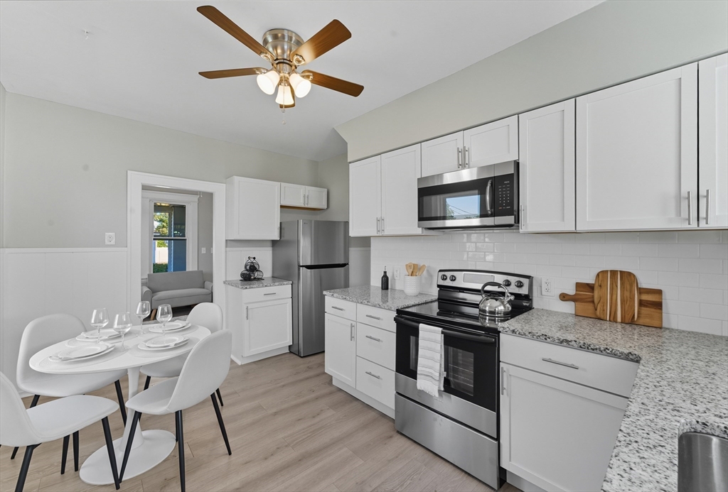 33 Taber Street Springfield, MA 01118 - Photo 10 of 39 a kitchen with a stove a microwave and white cabinets