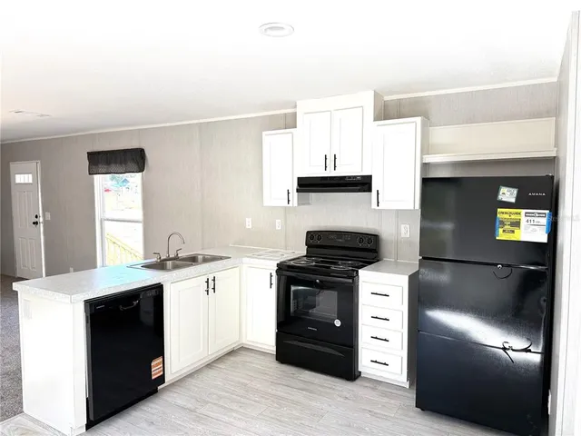 a kitchen with stainless steel appliances kitchen island granite countertop a stove a sink and a refrigerator