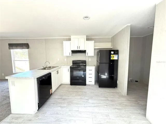 a kitchen with granite countertop a refrigerator and a stove top oven