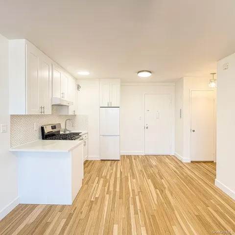 a kitchen with wooden floor and white appliances