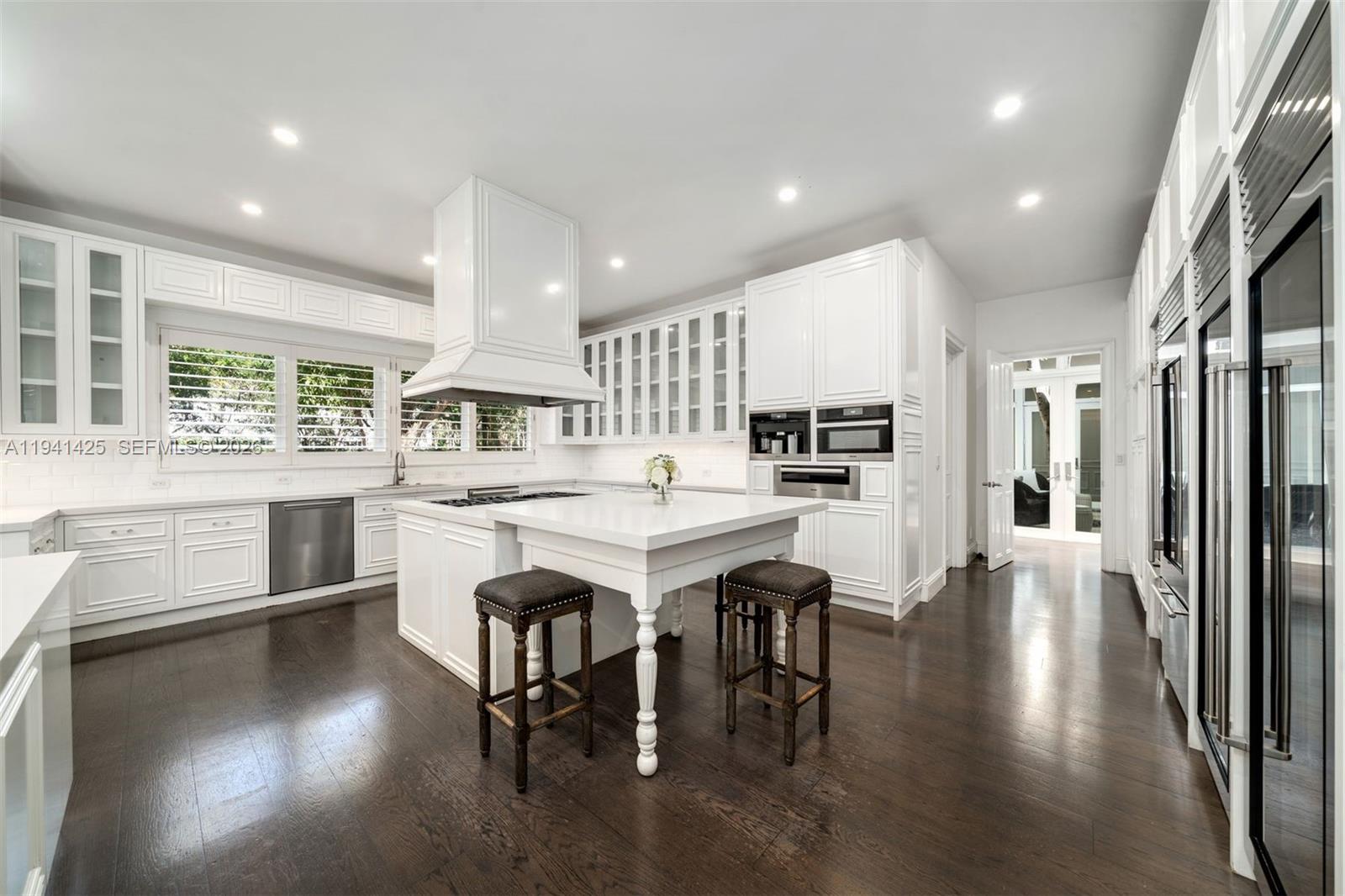 4100 Kiaora Street Miami, FL 33133 - Photo 6 of 26 a kitchen with a table chairs refrigerator and cabinets
