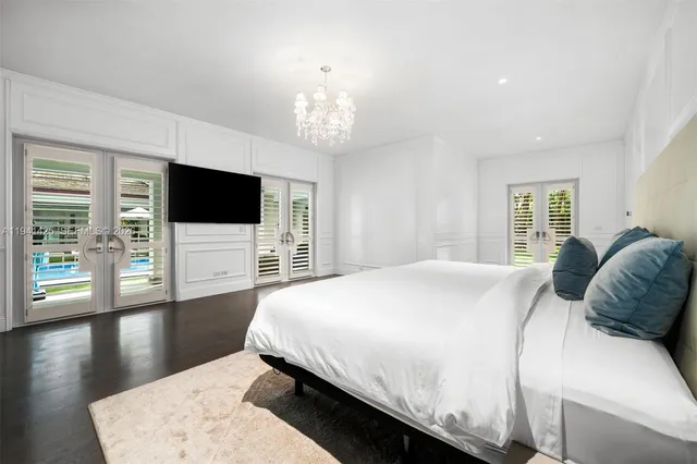 a bedroom with a large bed and a flat screen tv