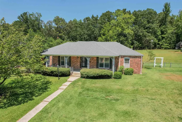 a view of a house with a yard and potted plants