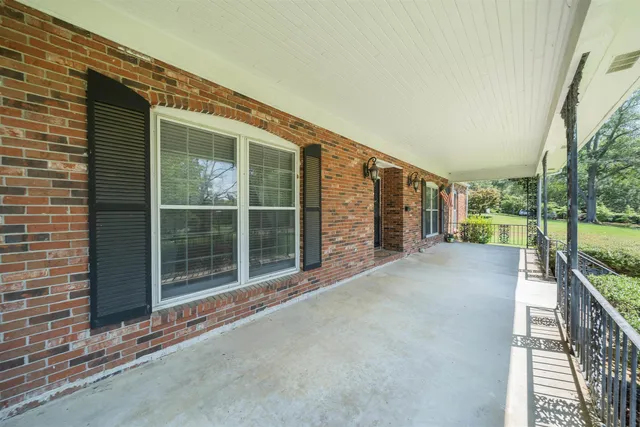 a view of a house with a floor to ceiling windows and a small yard