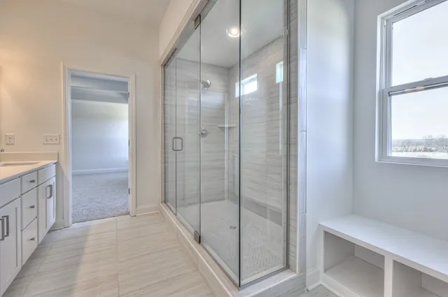 a bathroom with a glass shower door and a sink
