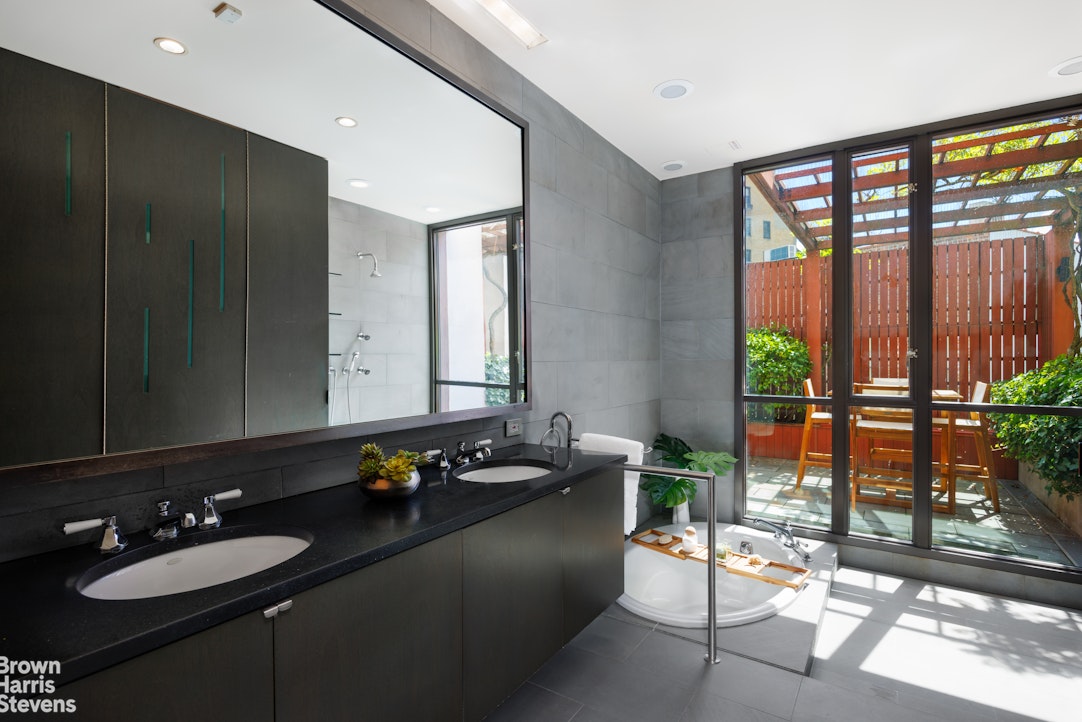 42 Downing Street Manhattan, NY 10014 - Photo 10 of 25 a bathroom with a double vanity sink and a mirror
