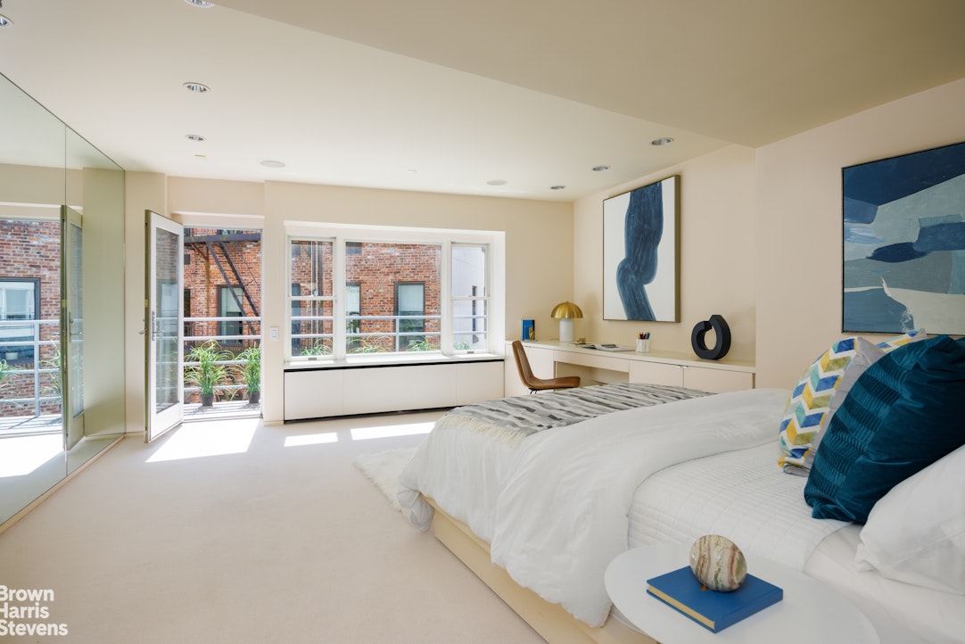 42 Downing Street Manhattan, NY 10014 - Photo 12 of 25 a bed room with a bed and a large window