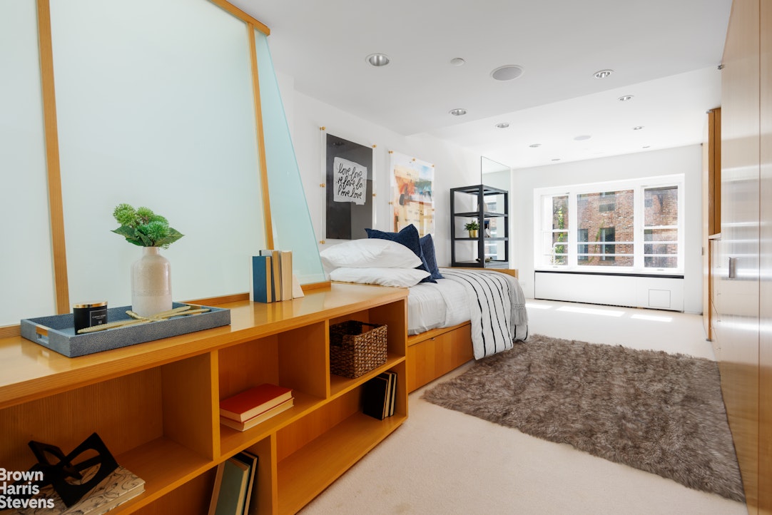 42 Downing Street Manhattan, NY 10014 - Photo 13 of 25 a bedroom with furniture and a window