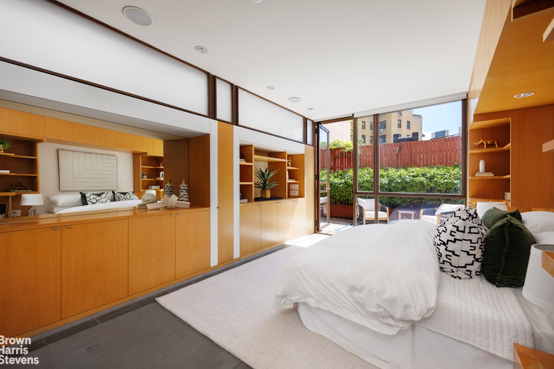 42 Downing Street Manhattan, NY 10014 - Photo 9 of 25 a bed room with a bed and a large window