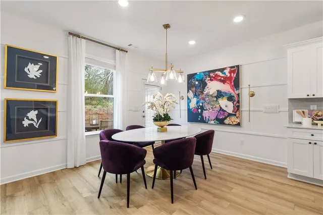 a view of a dining room with furniture a chandelier and wooden floor