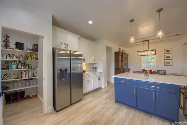a kitchen with refrigerator and cabinets