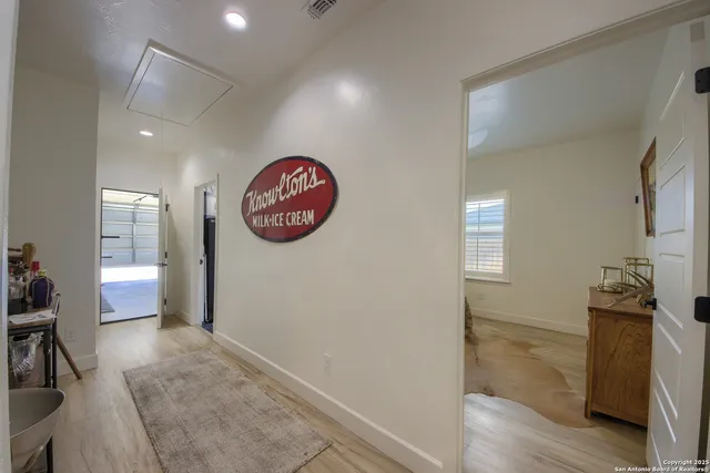 a view of a hallway to a livingroom with furniture