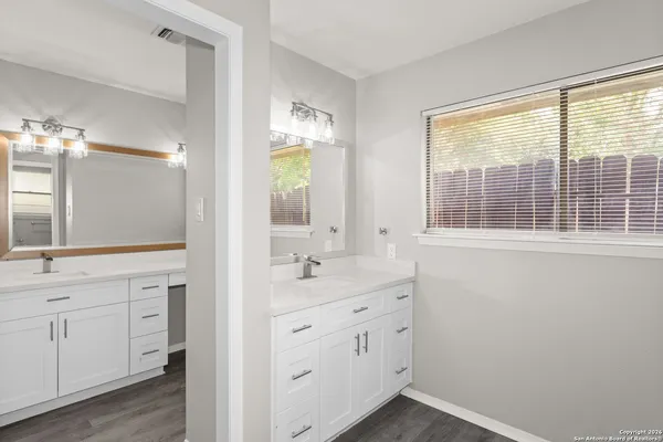 a bathroom with a sink a vanity a window and a mirror