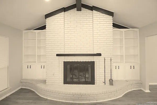 a view of a livingroom with fireplace and cabinet