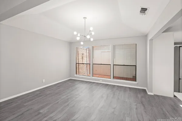 an empty room with wooden floor and window