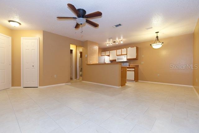 621 Dory Lane, Unit 103 Altamonte Springs, FL 32714 - Photo 3 of 13 an empty room with a kitchen and a ceiling fan