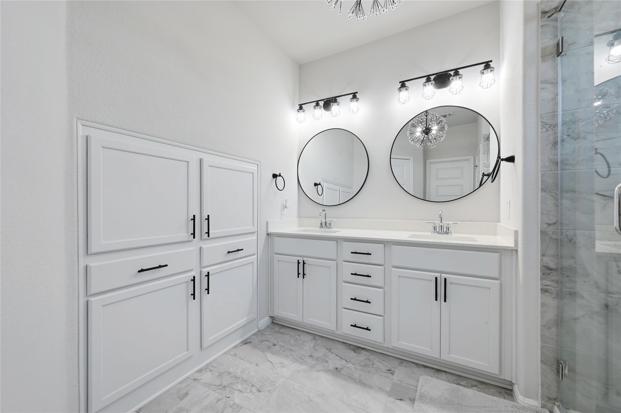 207 Dogvane Circle Kyle, TX 78640 - Photo 16 of 32 Bathroom with double vanity, light marble finish floors, a marble finish shower, and hanging lights