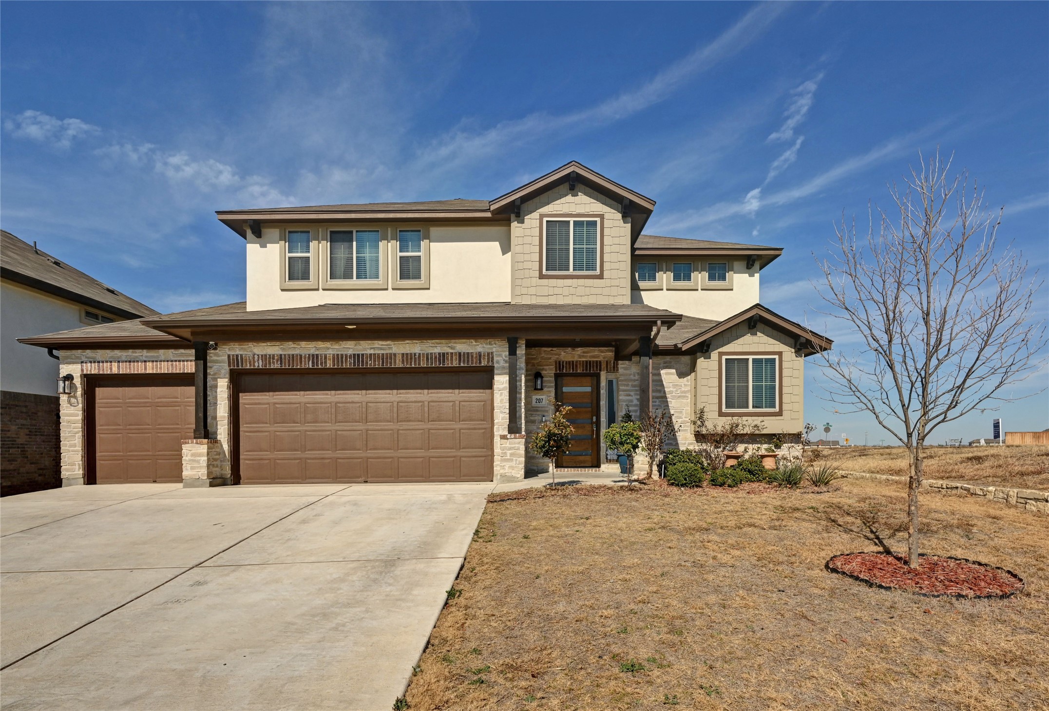 207 Dogvane Circle Kyle, TX 78640 - Photo 2 of 32 View of front of property with concrete driveway, an attached garage, a porch, and stucco siding