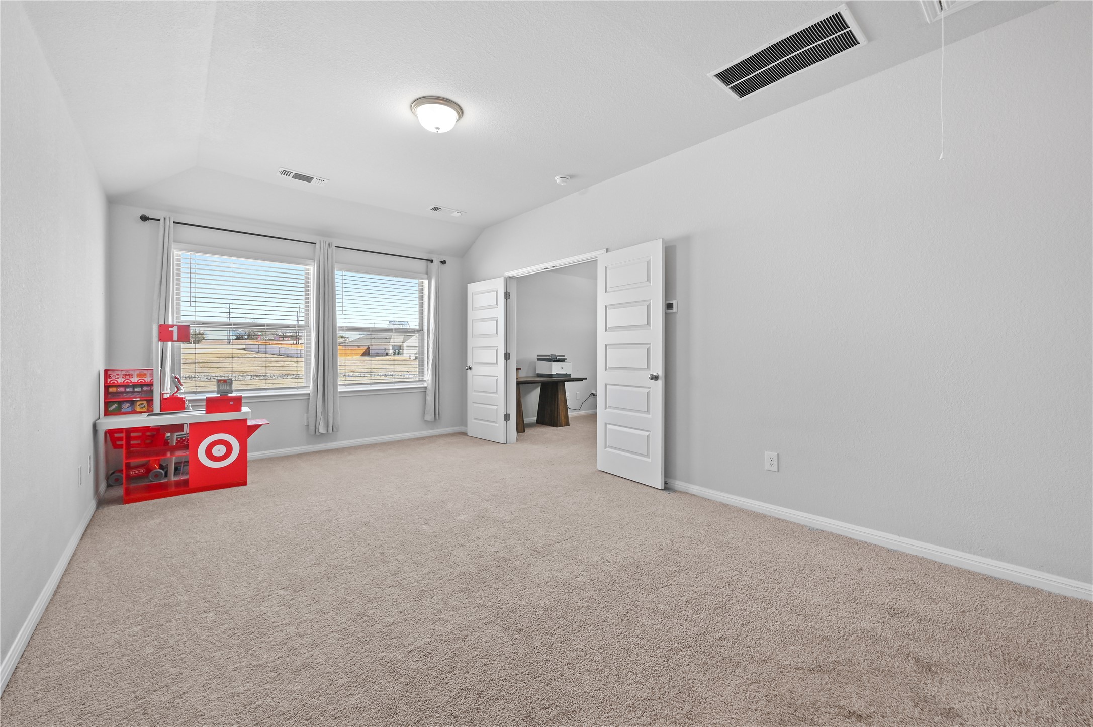 207 Dogvane Circle Kyle, TX 78640 - Photo 21 of 32 Bedroom with vaulted ceiling and light colored carpet