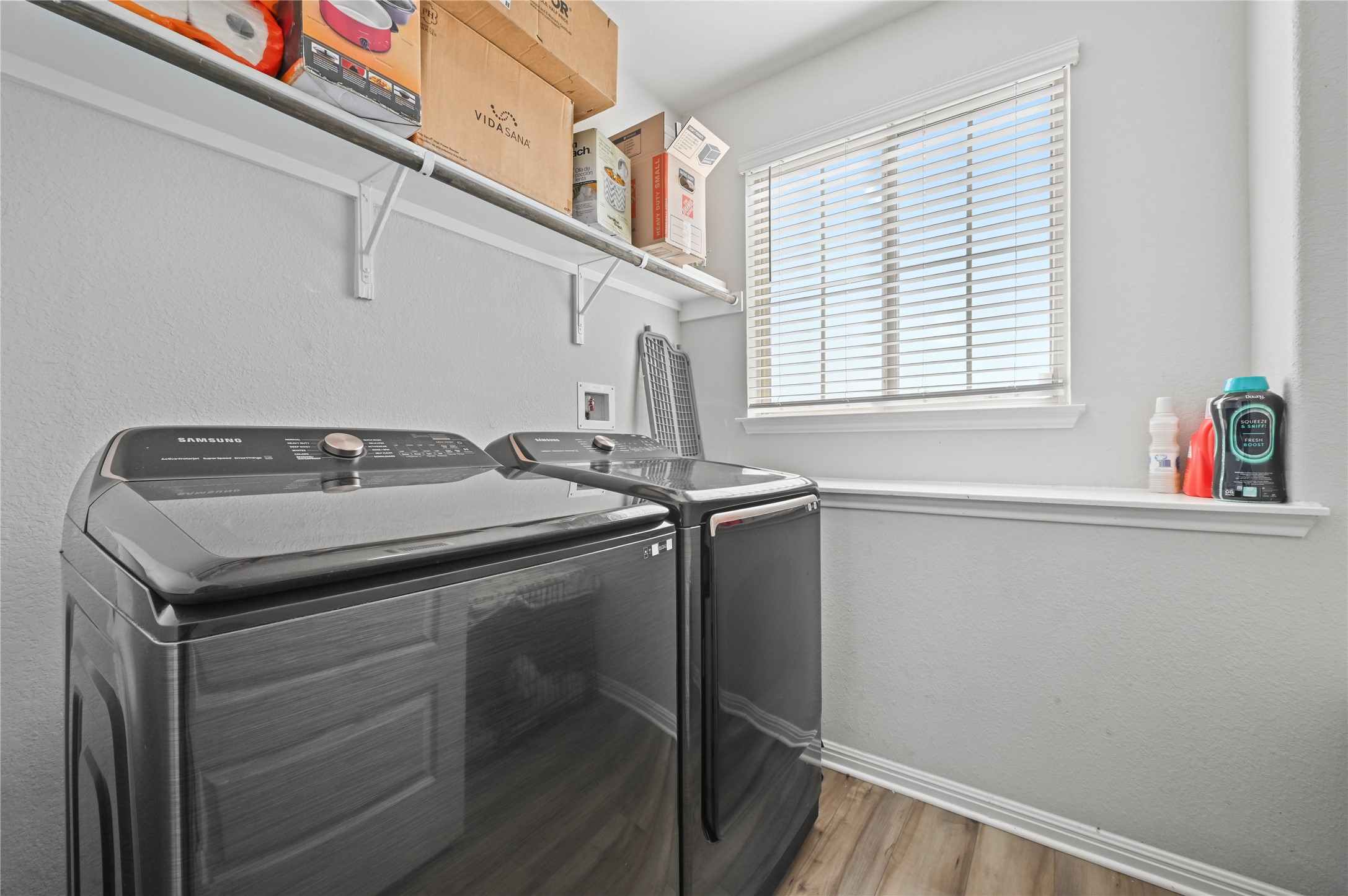 207 Dogvane Circle Kyle, TX 78640 - Photo 28 of 32 Laundry area with light wood-type flooring, separate washer and dryer, and a textured wall