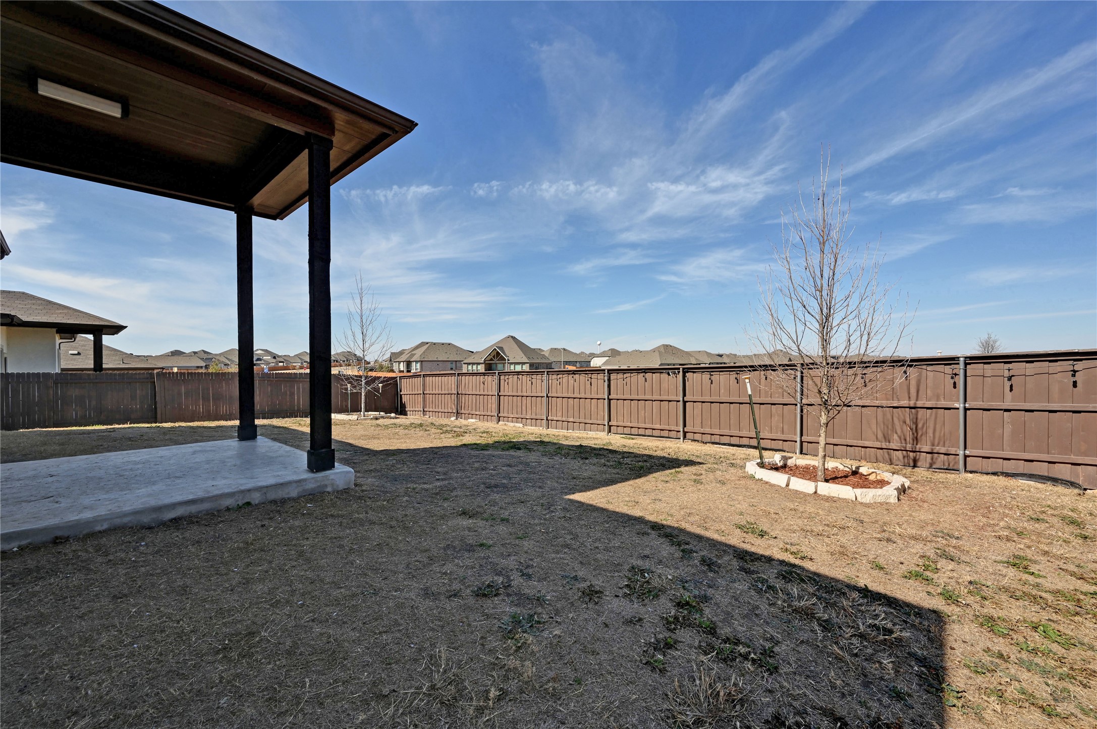 207 Dogvane Circle Kyle, TX 78640 - Photo 30 of 32 Fenced backyard featuring a residential view and a patio