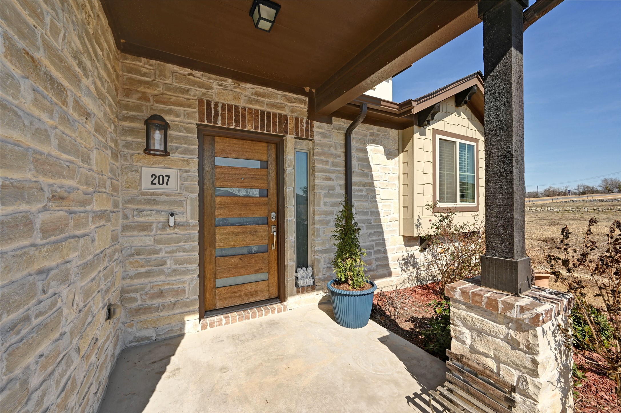 207 Dogvane Circle Kyle, TX 78640 - Photo 3 of 32 View of exterior entry featuring stone siding and covered porch