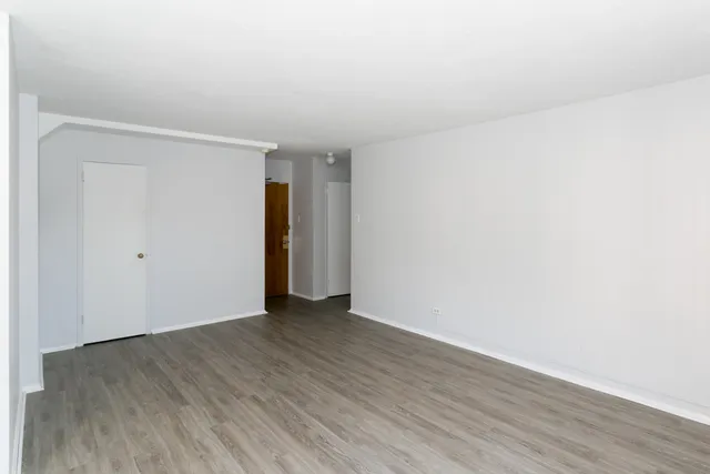 a view of an empty room with wooden floor