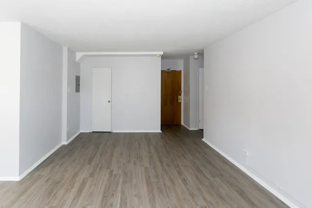 a view of an empty room with wooden floor