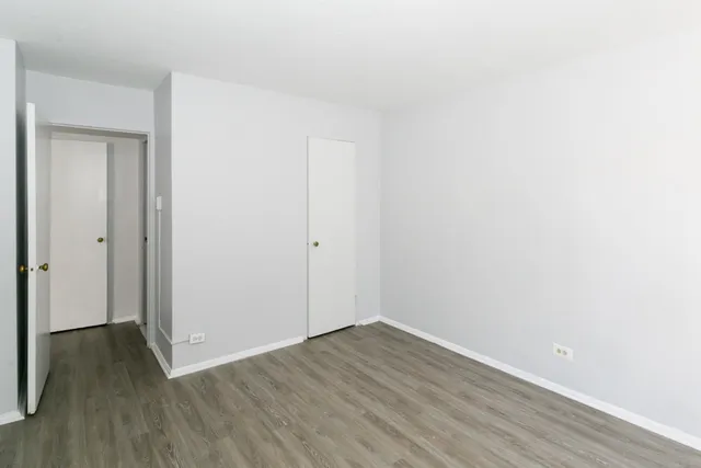 a view of an empty room with wooden floor